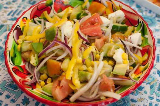 Foto de ensalada con maíz, cebolla, tomate, mozzarella, pimientos, pepino y aguacate